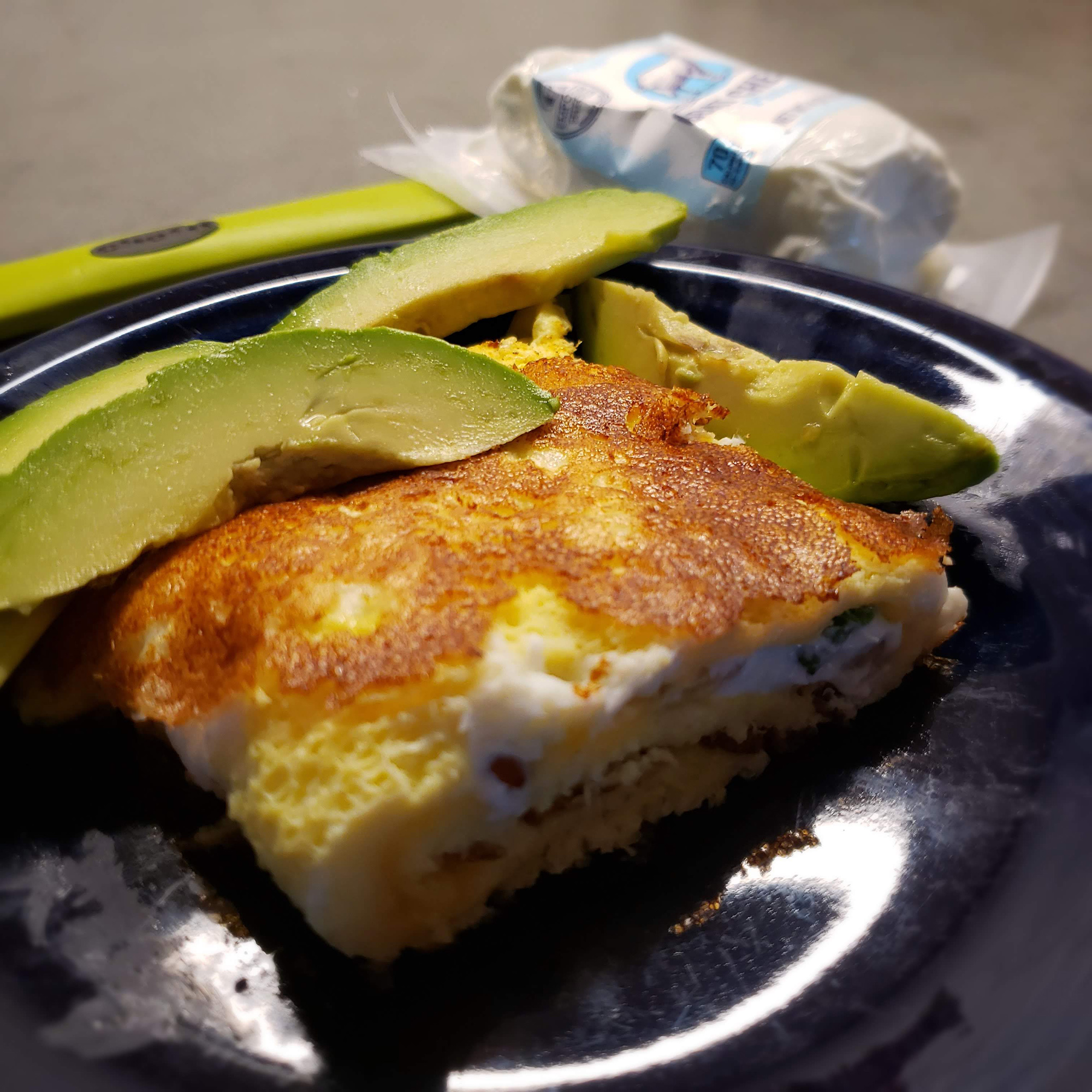 Plated omelette with avocado slices